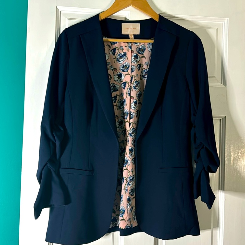 Skies are blue stretchy navy blazer with rouched sleeves and floral lining. NWOT
